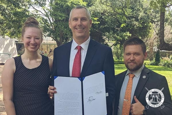 TXGR Executive Director Chris McNutt and Director of Legislation Bethany Young with Texas State Representative Matt Schaefer holding Texas' signed Constitutional Carry bill.